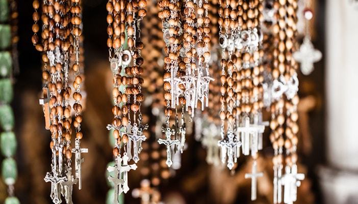 Rosary beads with Jesus Christ crosses in a church shop display.