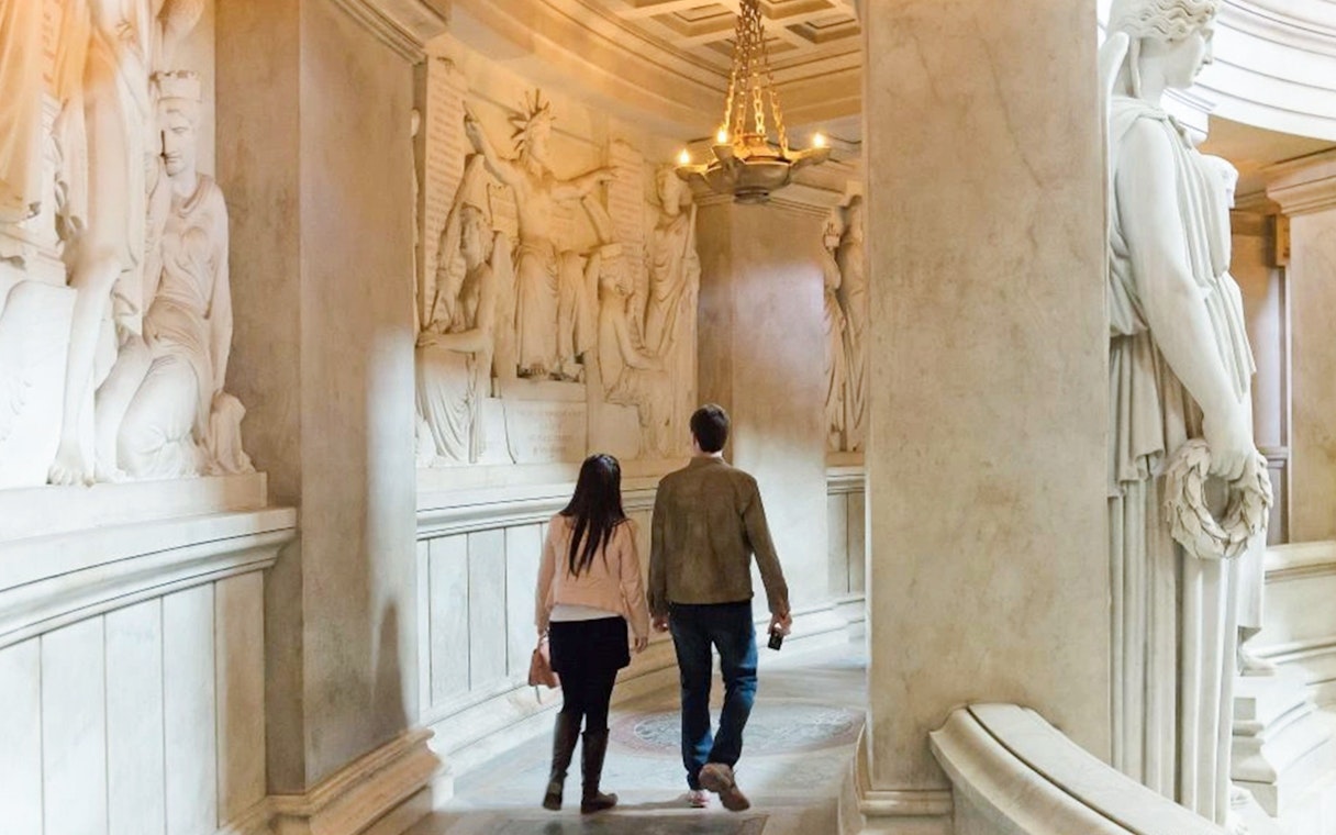 Couple walking through Invalides Napoleon's Tomb in Paris, France.