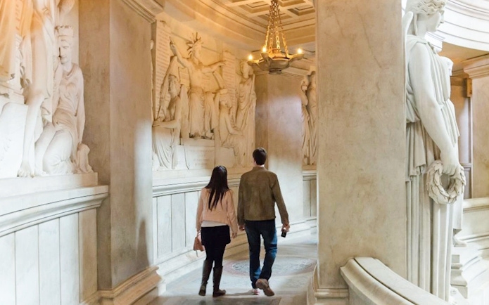 Couple walking through Invalides Napoleon's Tomb in Paris, France.