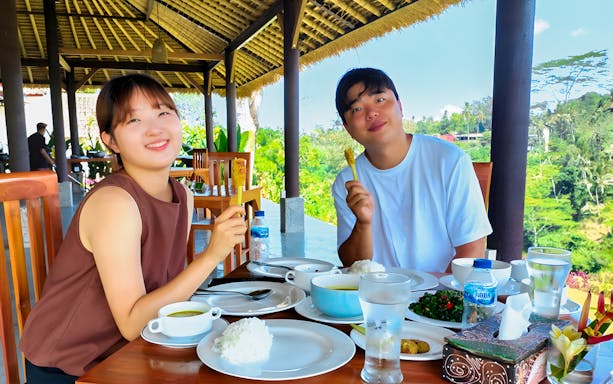 Participants enjoying a meal at Bakas Cooking Class with Canggu countryside views.