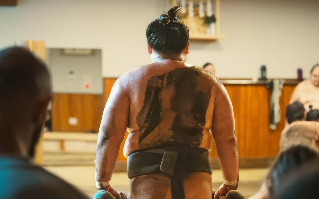 Sumo wrestler preparing for a match in a traditional Japanese dojo.