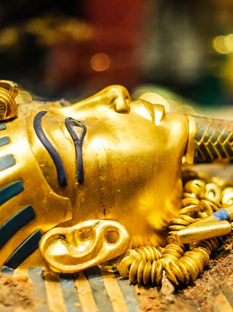 Tutankhamun's golden mask with intricate blue and gold detailing.