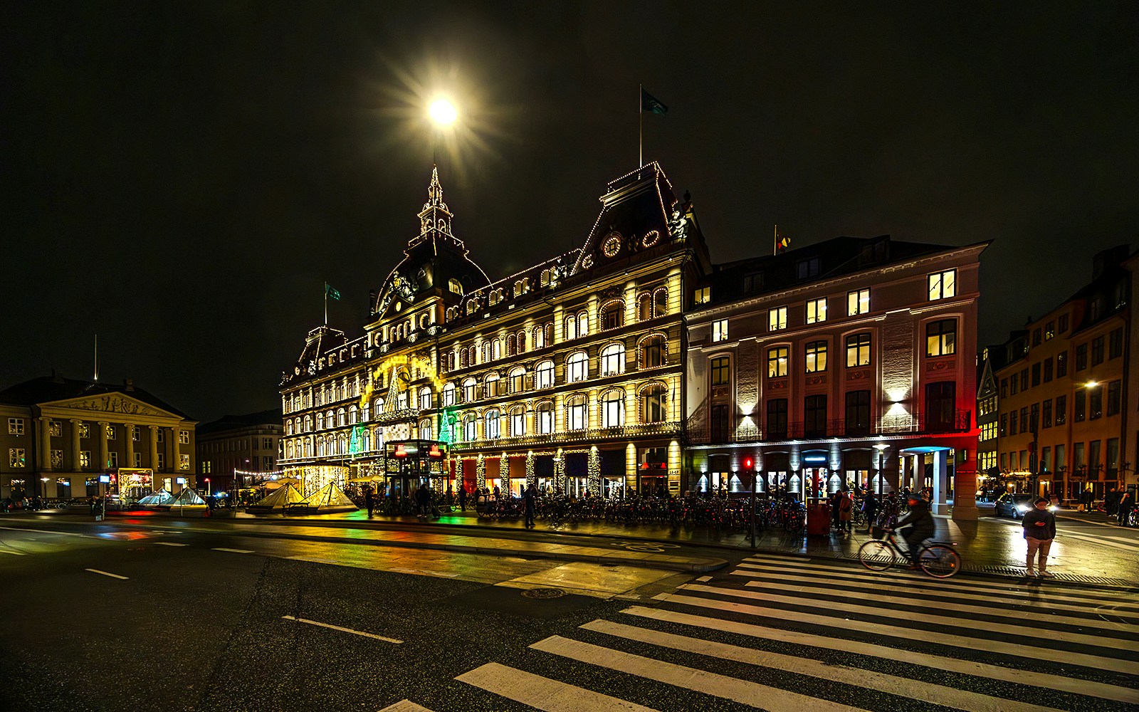 Kongens Nytorv at night with illuminated historic building in Copenhagen.