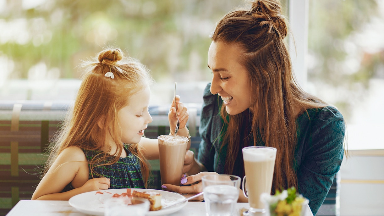 Mother and daughter enjoying a meal at a café.