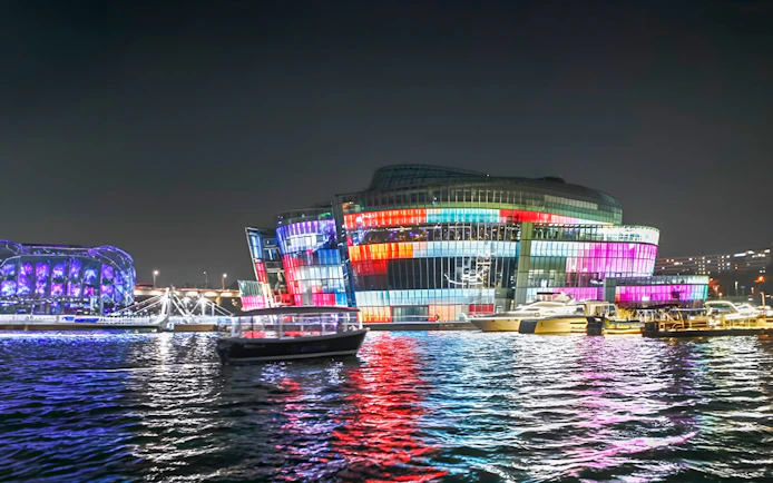 Yachts on Han River at night with colorful lights, Seoul Golden Blue Marina.