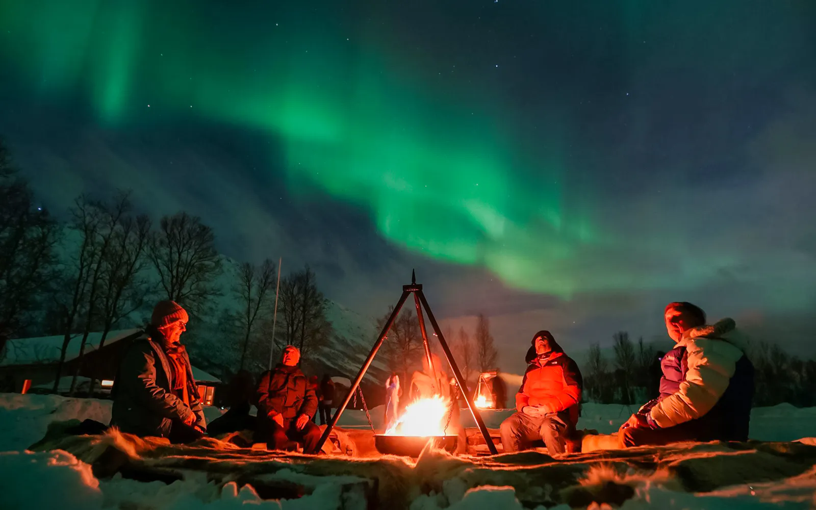 Campfire under Northern Lights at a safari camp in Tromsø.