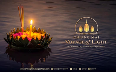 Floating krathong with candle and incense on water during Chiang Mai Voyage of Light festival.