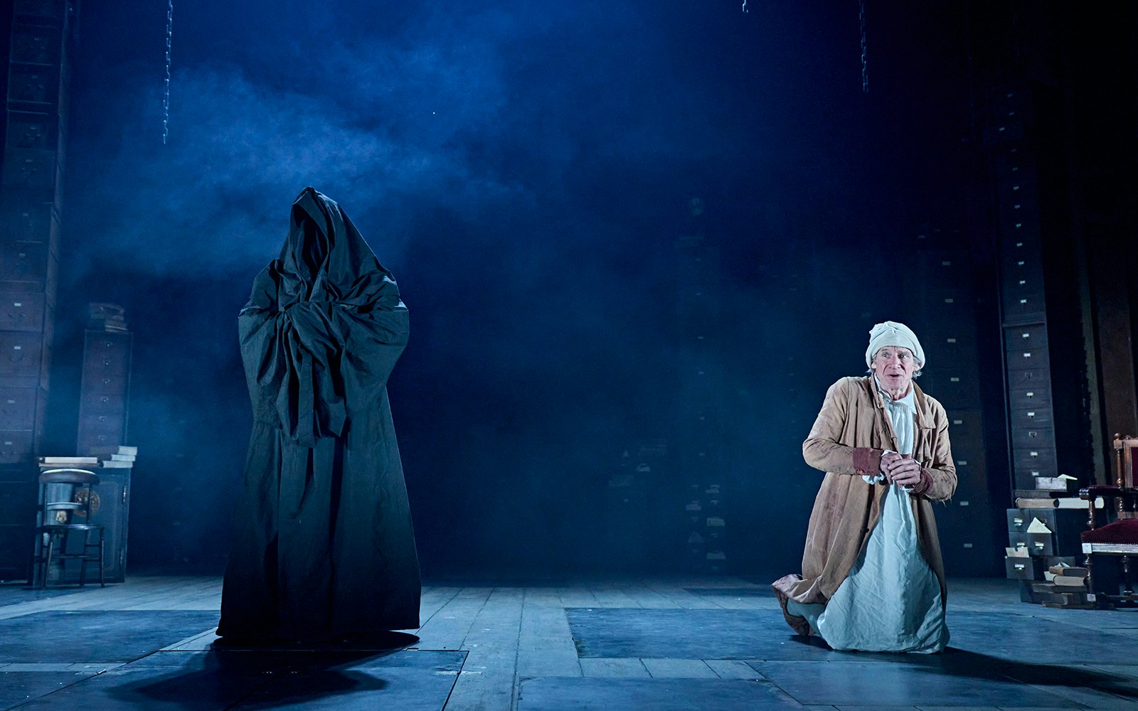 Ghostly figure and man in nightgown on stage during "A Christmas Carol - A Ghost Story" performance.