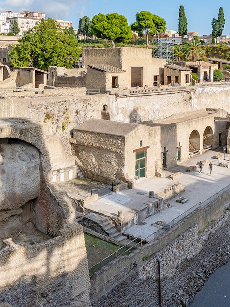 Ruins of Herculaneum entrance with ancient stone structures and arches, Italy.
