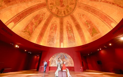Fresco on dome at Notre-Dame de Paris Exhibition with visitors observing artwork.
