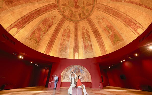 Fresco on dome at Notre-Dame de Paris Exhibition with visitors observing artwork.