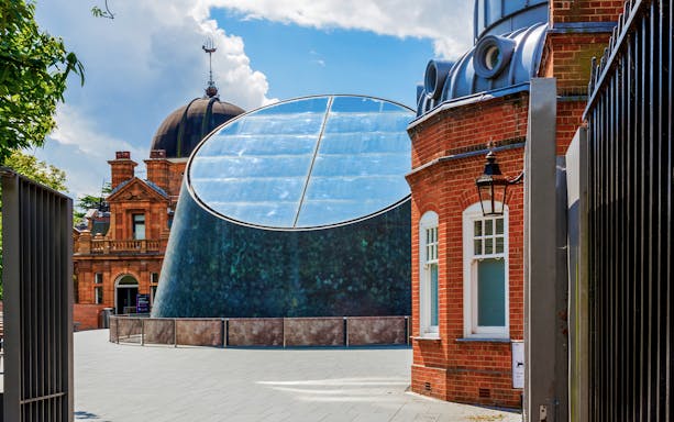 Royal Observatory Planetarium exterior with modern glass dome and historic brick building.