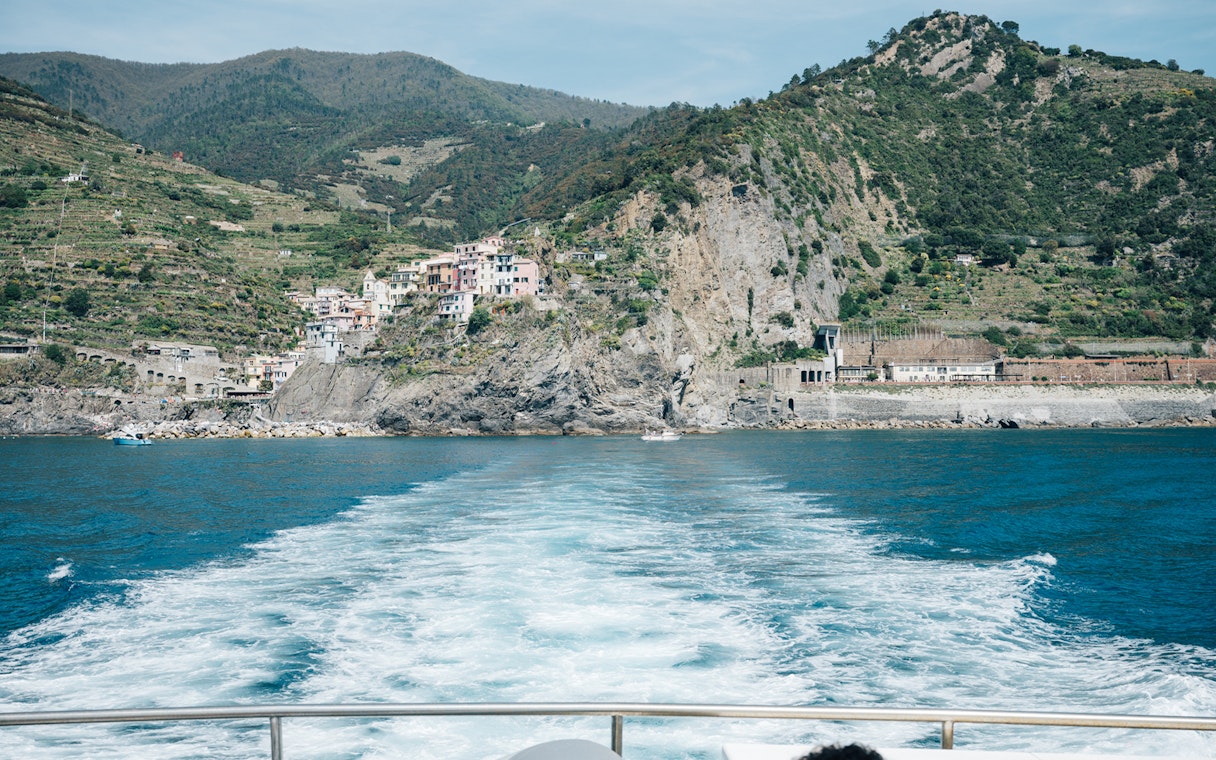 Cinque Terre coastline view with colorful hillside village and sea.