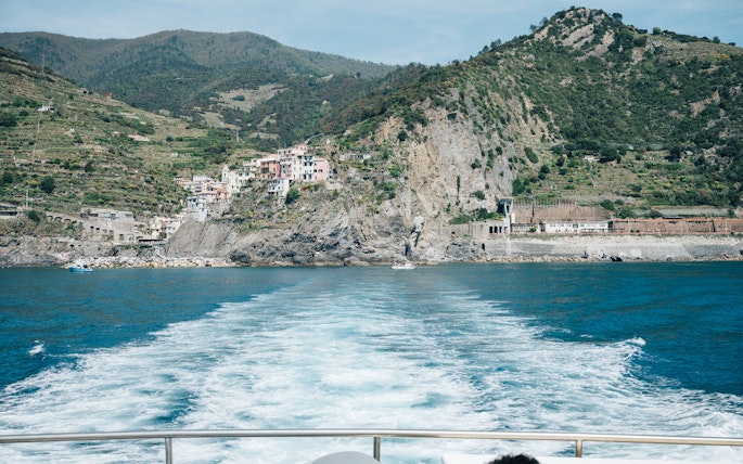 Cinque Terre coastline view with colorful hillside village and sea.