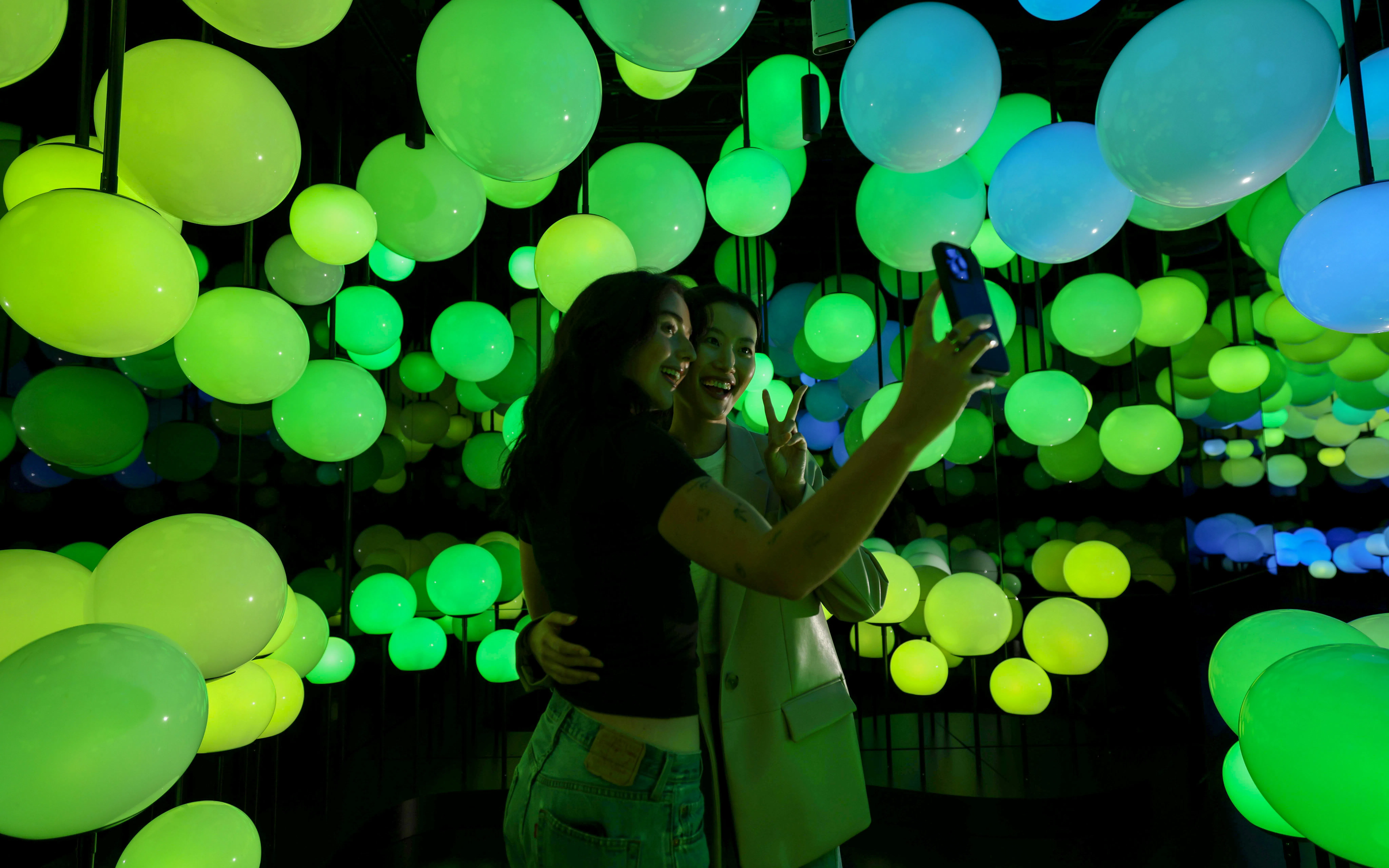 Visitors taking a selfie in the illuminated interior of Edge Observatory, New York.