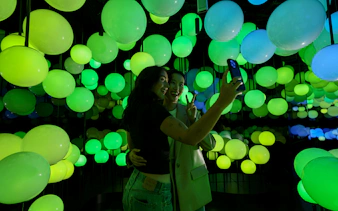 Visitors taking a selfie in the illuminated interior of Edge Observatory, New York.