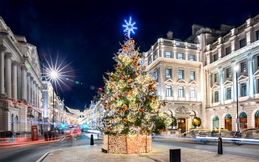 Festive Christmas tree with lights in central London street at night.