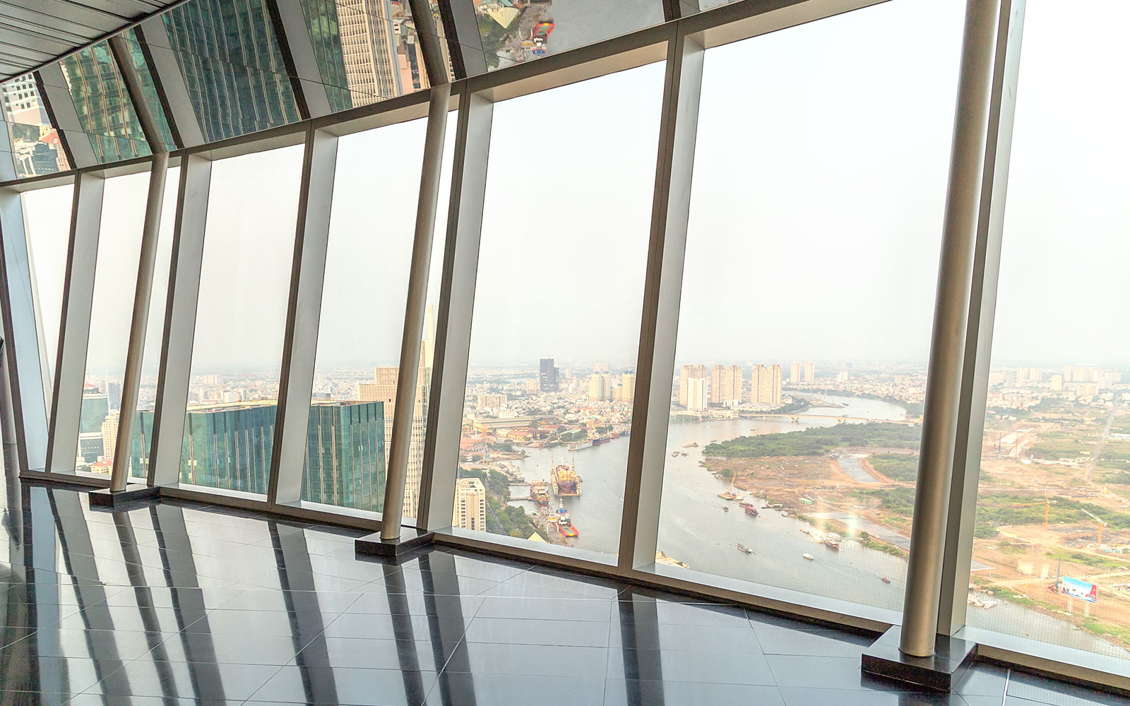 Panoramic view from sky deck in downtown Ho Chi Minh City, Vietnam, overlooking river and cityscape.
