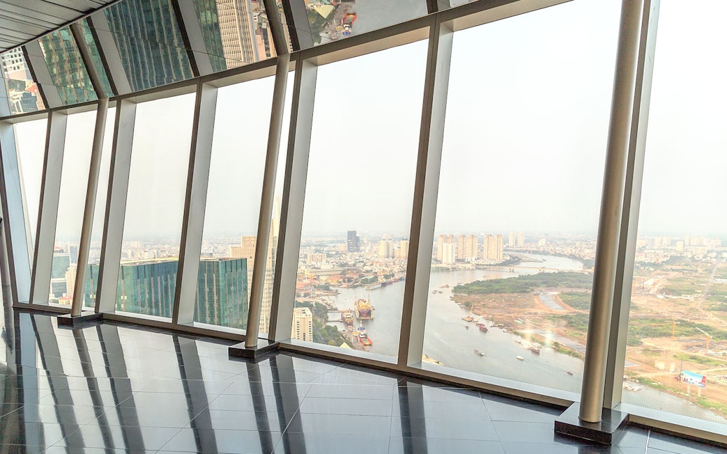 Panoramic view from sky deck in downtown Ho Chi Minh City, Vietnam, overlooking river and cityscape.