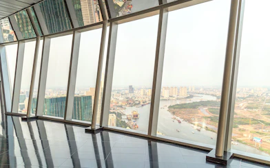 Panoramic view from sky deck in downtown Ho Chi Minh City, Vietnam, overlooking river and cityscape.