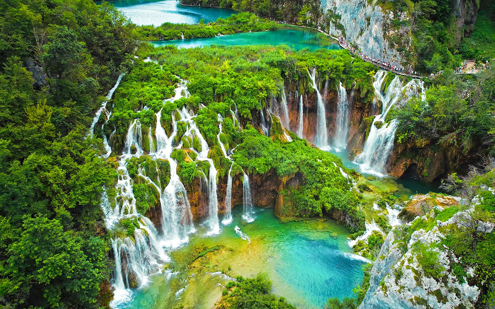 Waterfalls cascading into turquoise lakes at Plitvice Lakes National Park, Croatia.
