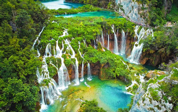 Waterfalls cascading into turquoise lakes at Plitvice Lakes National Park, Croatia.
