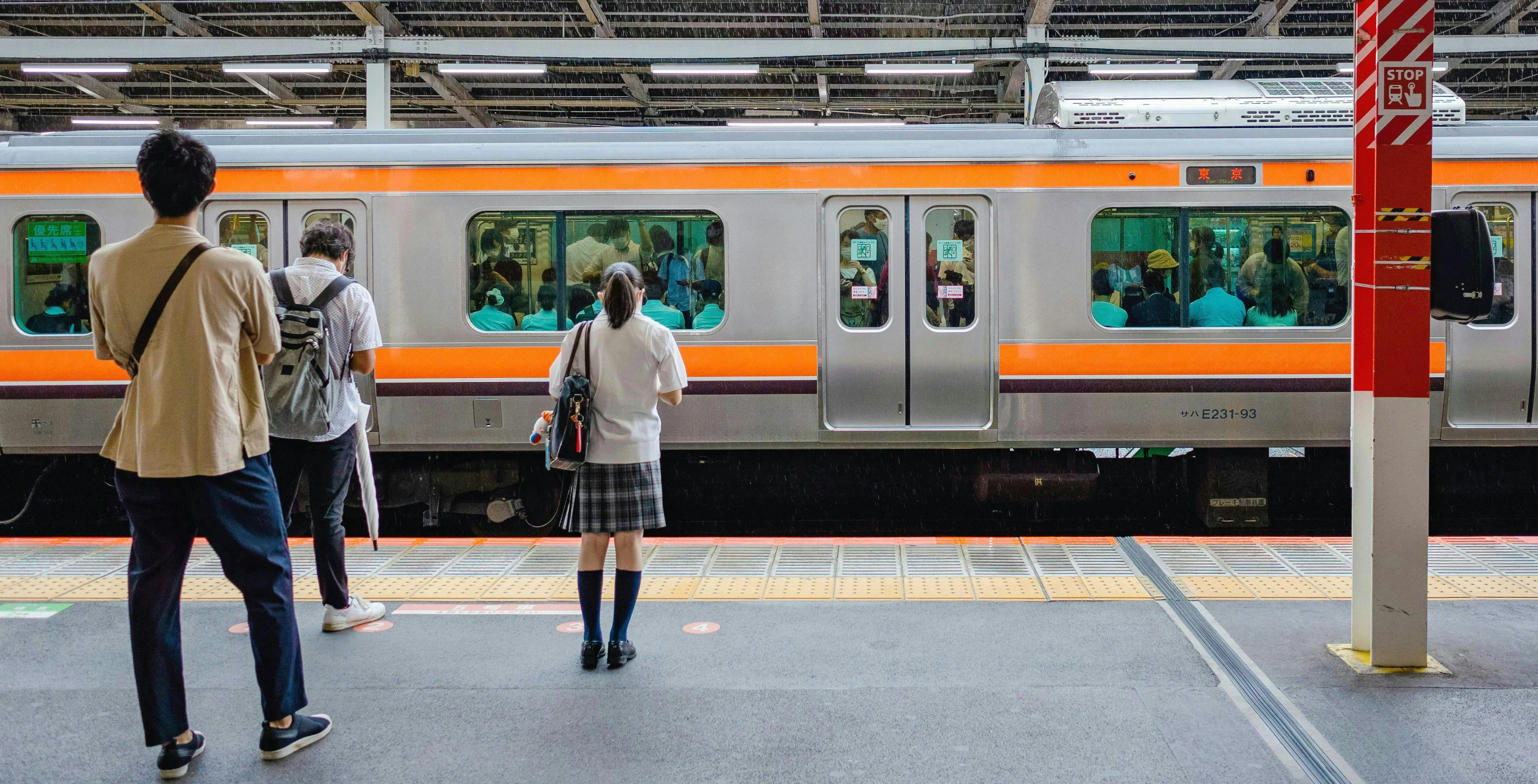 People waiting on a platform for a train at a Japanese station.