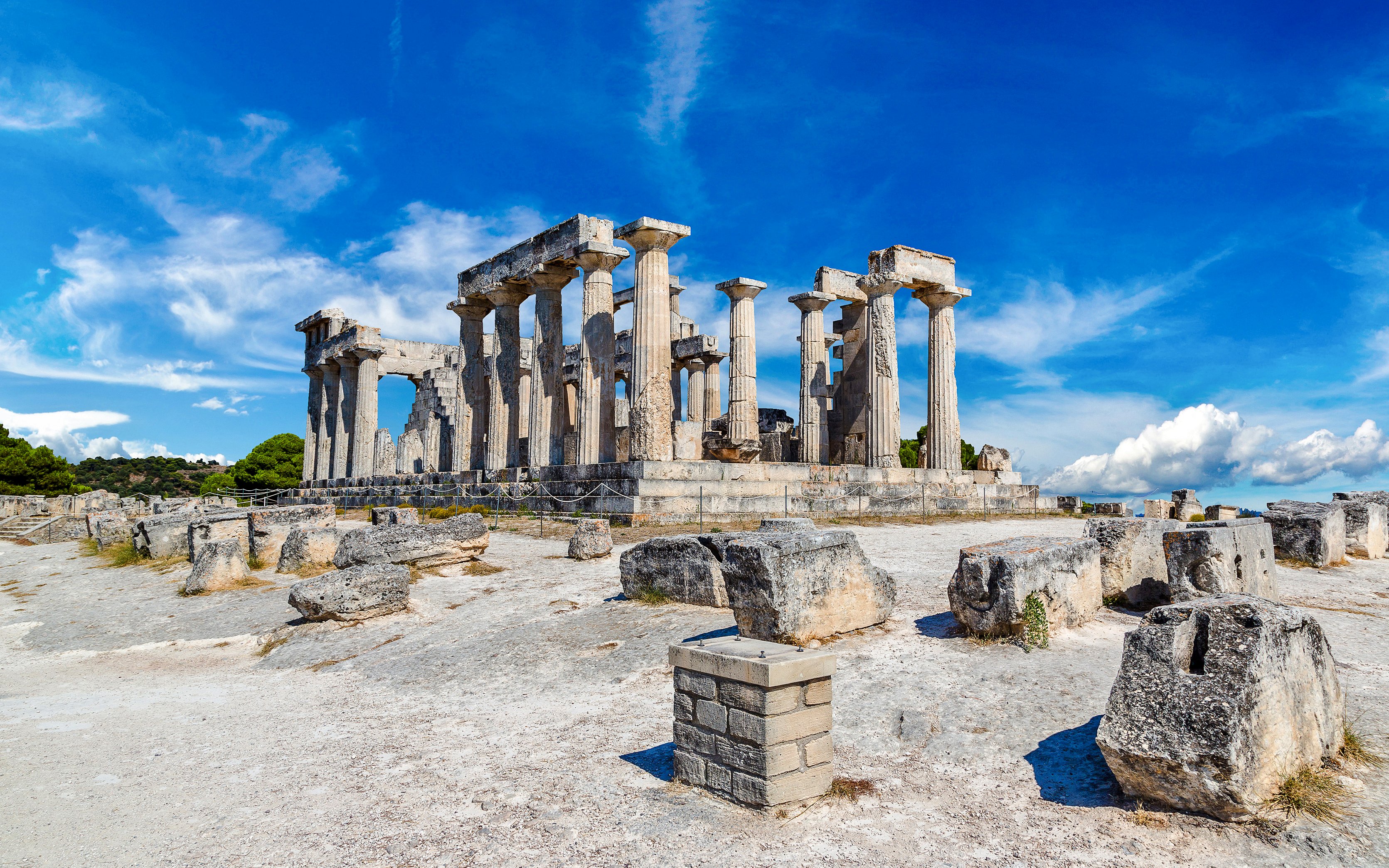 Aphaia Temple ruins with Doric columns on Aegina Island, Greece under a clear blue sky.