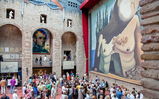 Dalí Theatre and Museum interior with large mural and visitors in Figueres, Spain.