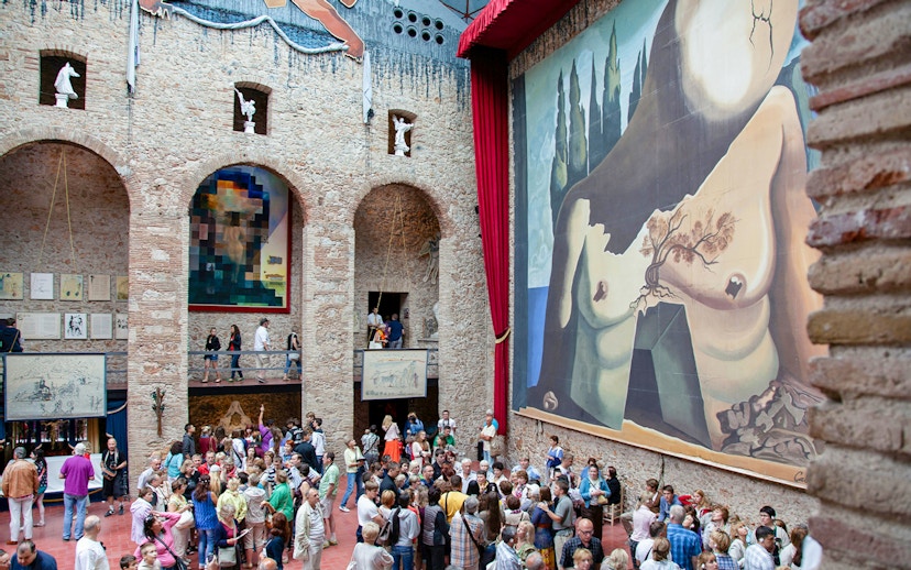 Dalí Theatre and Museum interior with large mural and visitors in Figueres, Spain.