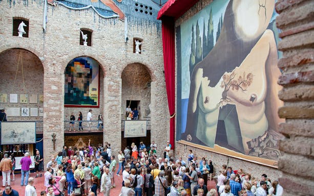 Dalí Theatre and Museum interior with large mural and visitors in Figueres, Spain.
