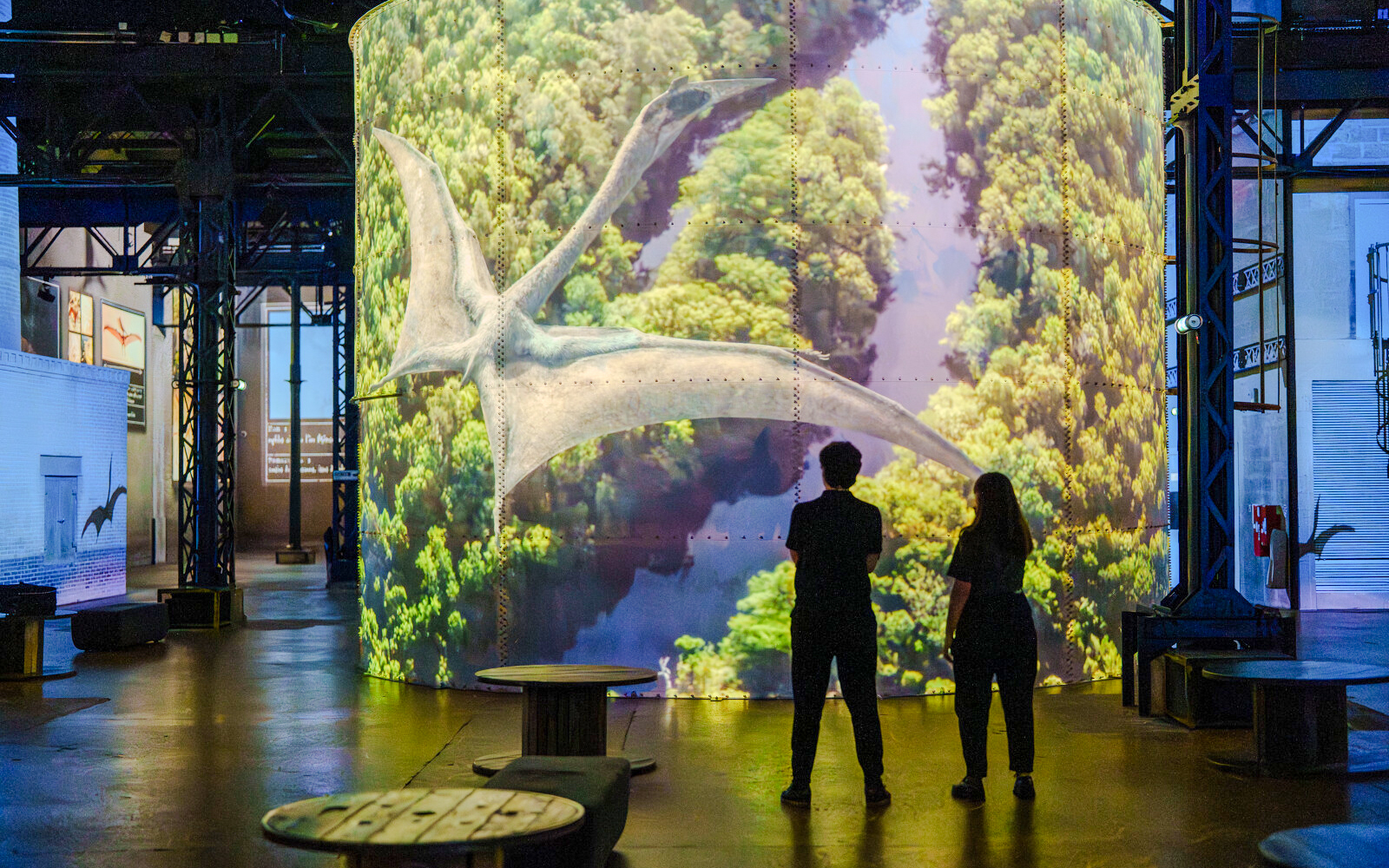 Visitors viewing a pterosaur projection at Prehistoric Planet: Discovering Dinosaurs exhibition, Atelier des Lumières.