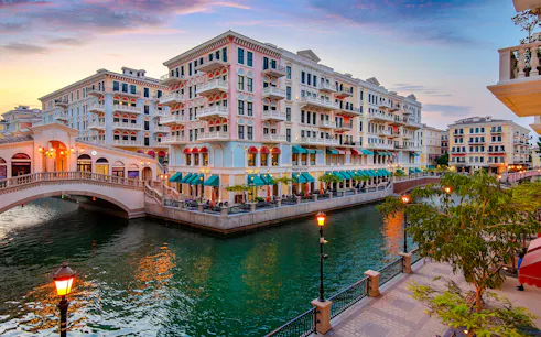 Colorful buildings and canal at sunset in The Pearl-Qatar, part of the Doha city tour.