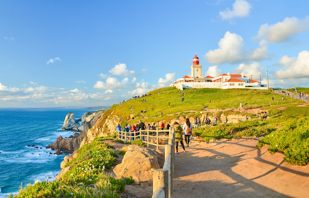 Tourists walking along the path near the lighthouse at Cabo da Roca, Portugal.