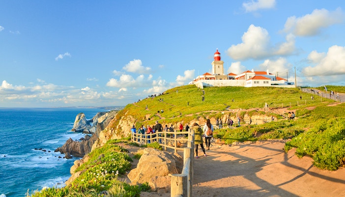 Tourists walking along the path near the lighthouse at Cabo da Roca, Portugal.