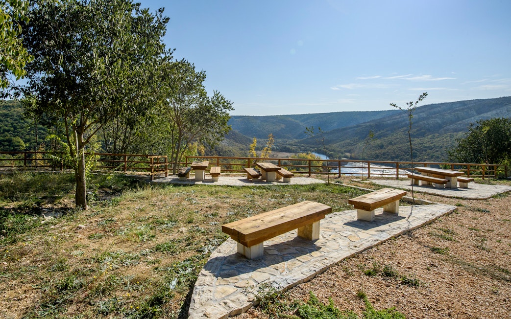 Seating area overlooking river and hills at Krka National Park viewpoint.