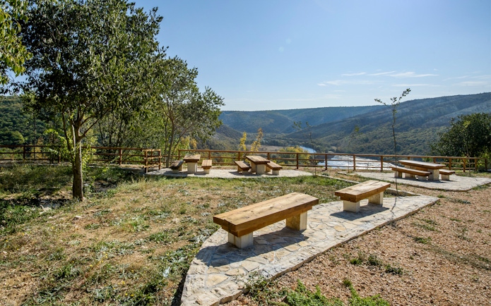 Seating area overlooking river and hills at Krka National Park viewpoint.