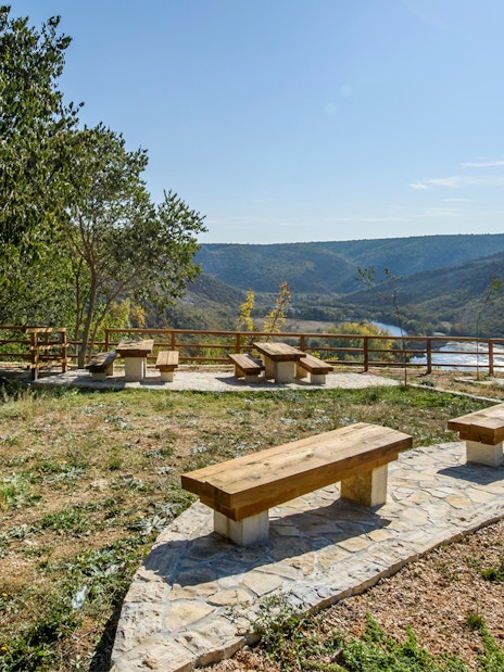 Seating area overlooking river and hills at Krka National Park viewpoint.