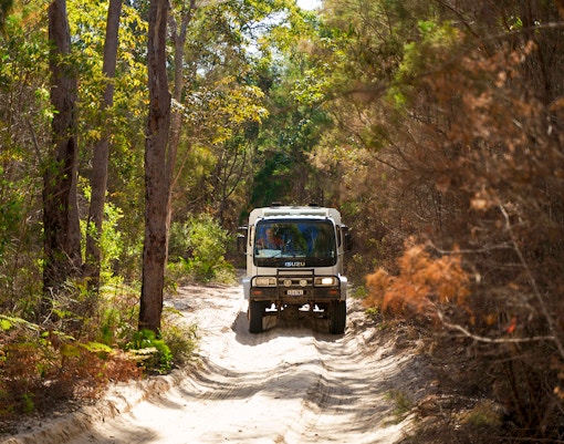 4WD vehicle navigating sandy terrain on Moreton Island, Australia.