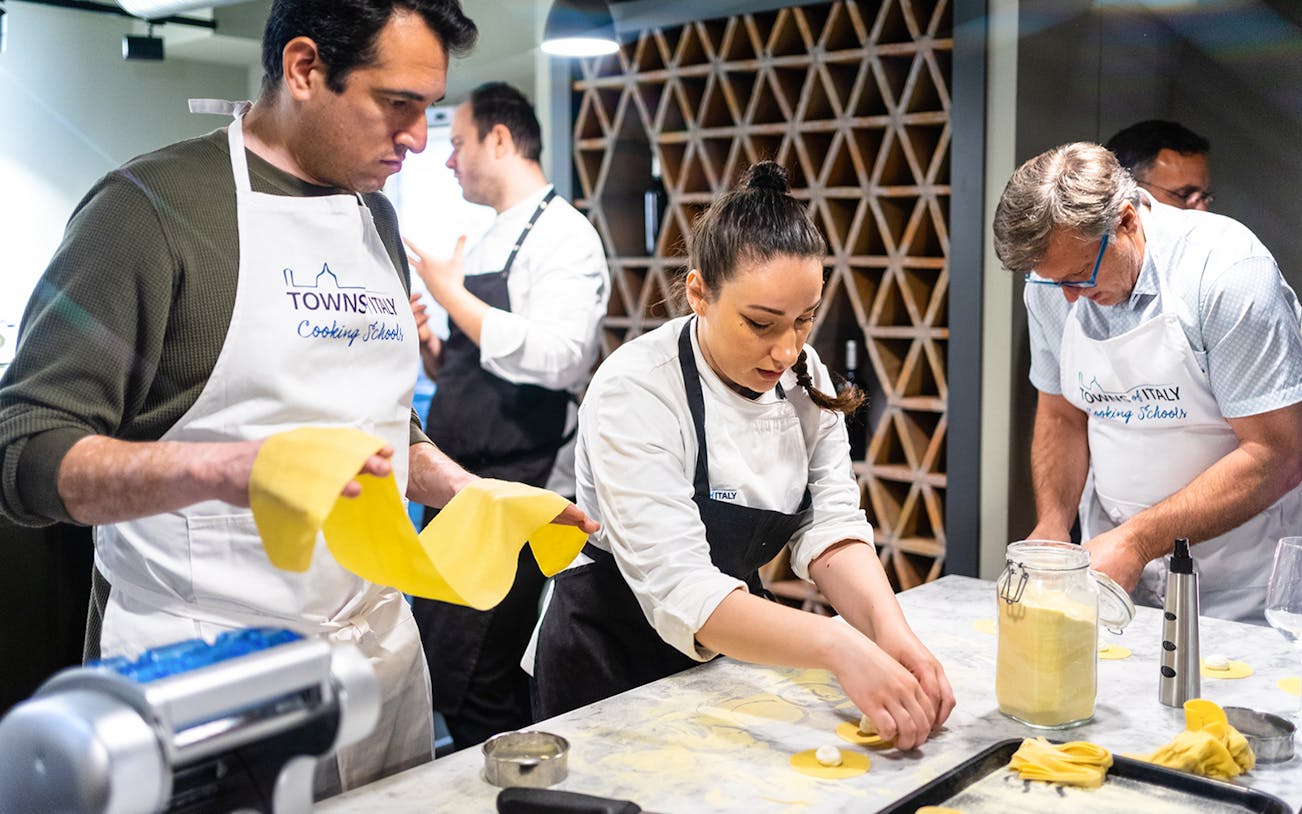 Cooking class participants making pasta at a culinary school.