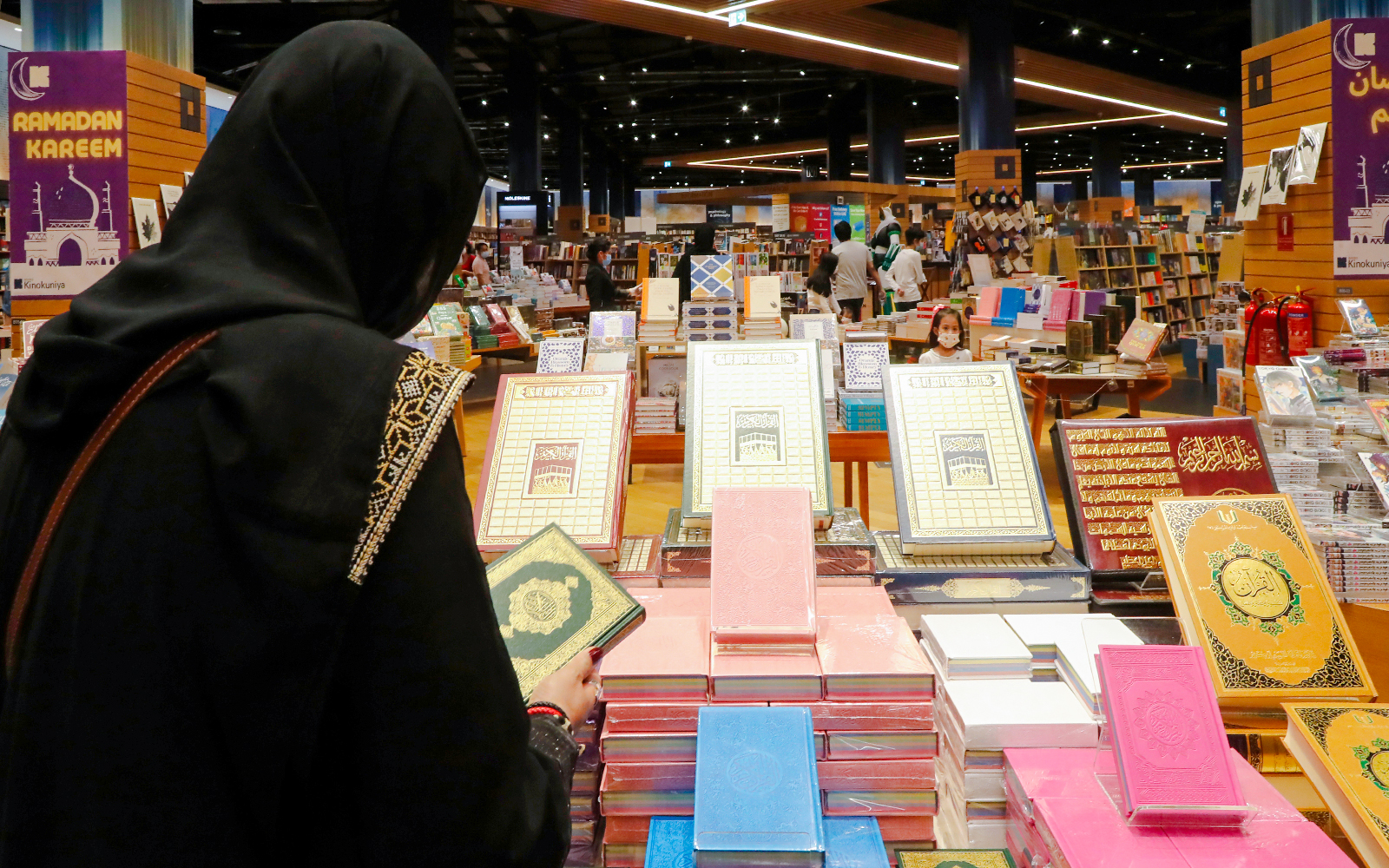 Woman browsing books at Kinokuniya Bookstore in Dubai.