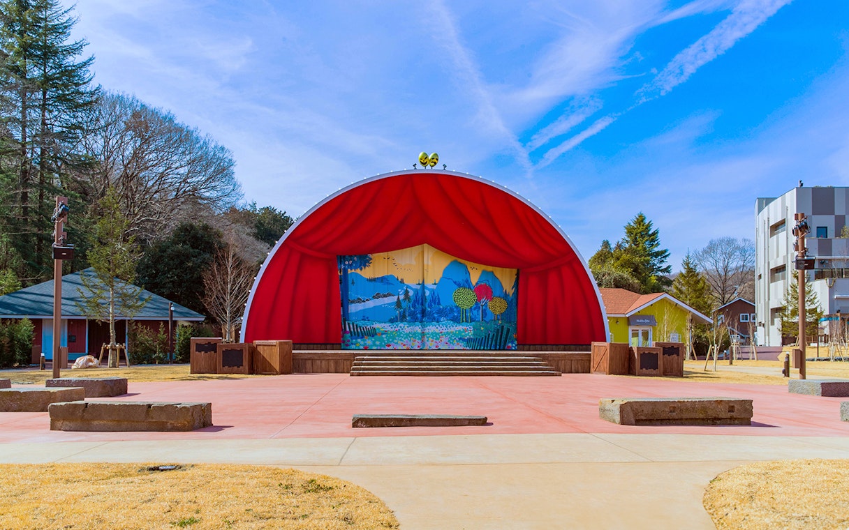Outdoor stage with red curtains at Moominvalley Park, Japan.