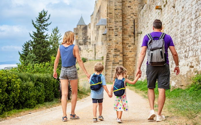 Family walking along the walls of Carcassonne Castle, France.