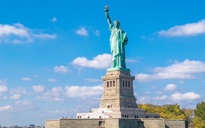 Statue of Liberty with New York City skyline, part of combo tour with Empire State Building and bus tour.