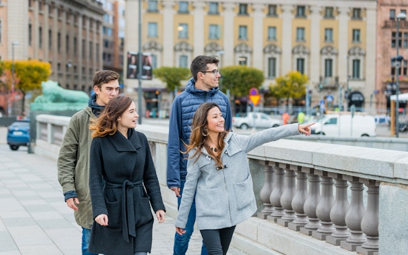 Tourists walking and pointing on a bridge in Stockholm.