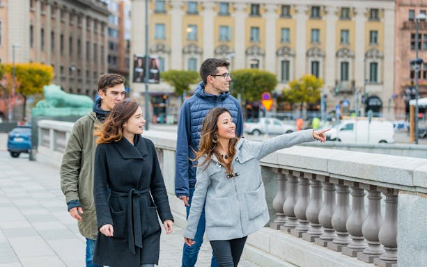 Tourists walking and pointing on a bridge in Stockholm.