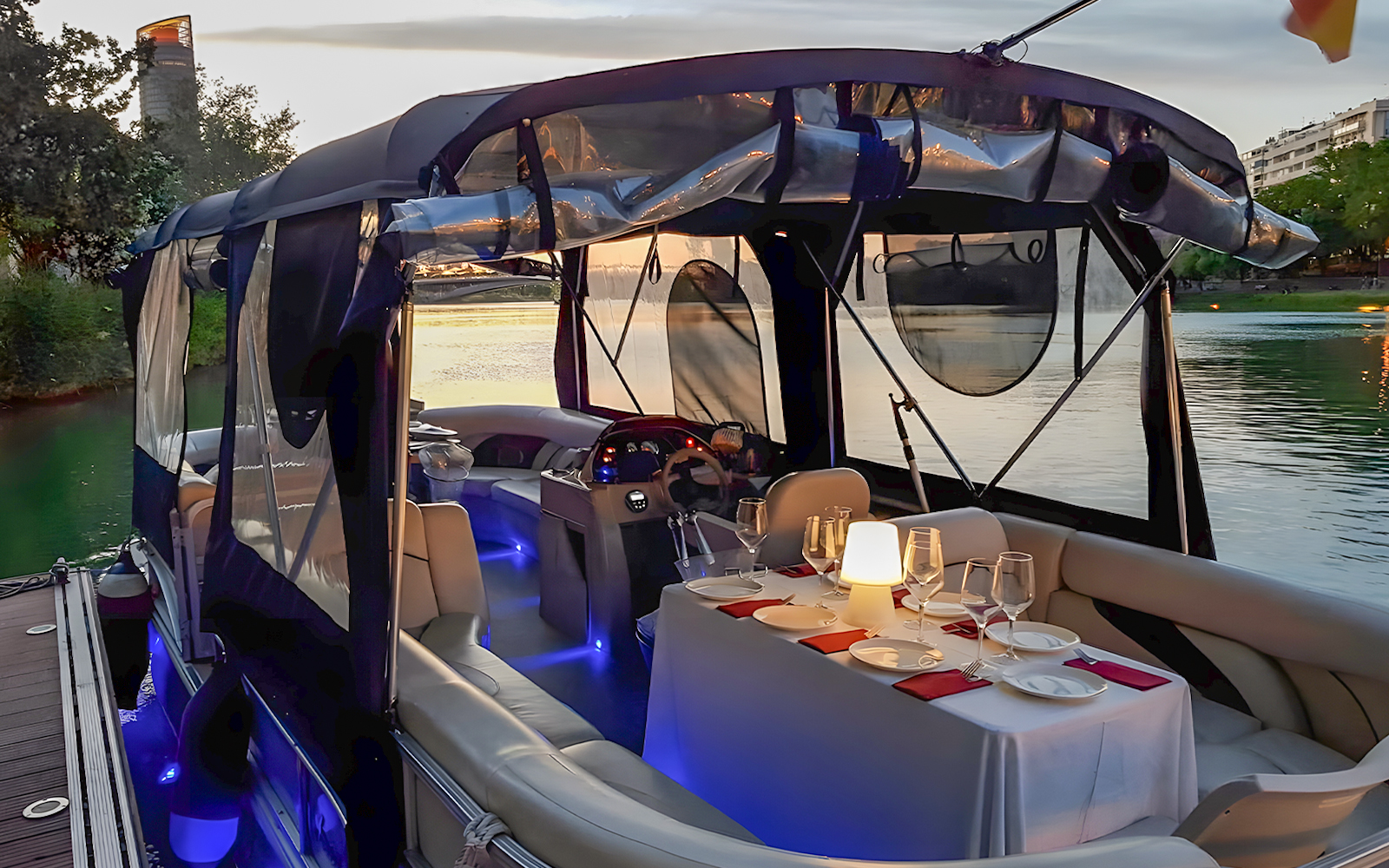 Guadalquivir River cruise boat with dining table set for tapas and drinks.