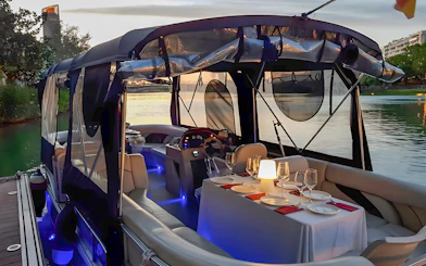 Guadalquivir River cruise boat with dining table set for tapas and drinks.