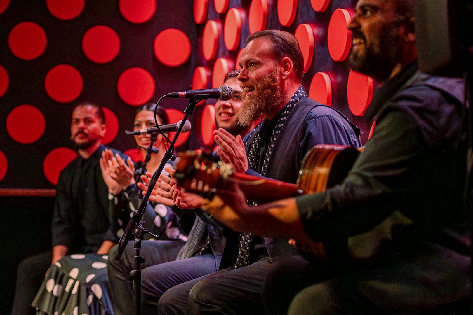 Flamenco performers clapping and playing guitar at Los Tarantos show.