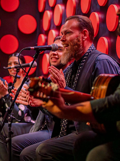 Flamenco performers clapping and playing guitar at Los Tarantos show.